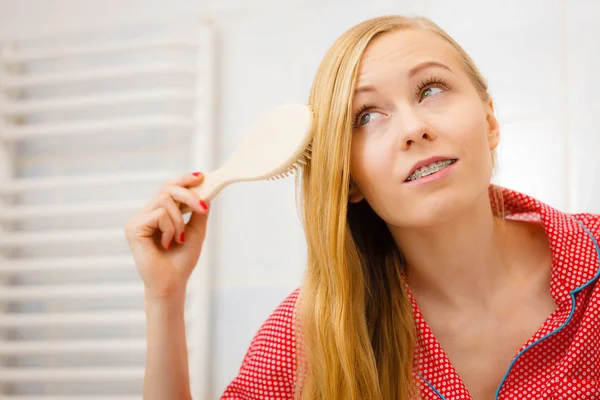 Kvinna borsta hennes långa hår i badrum — Stockfoto