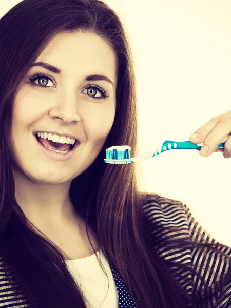Kvinna håller tandborste med pasta. — Stockfoto