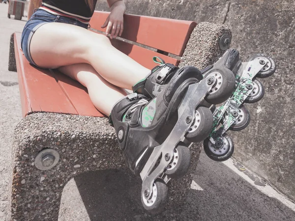 Femme sur banc portant des patins à roulettes — Photo