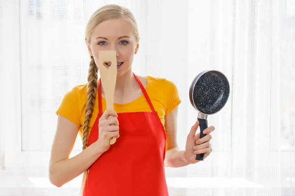 Женщина держит сковородку и лопатку — стоковое фото