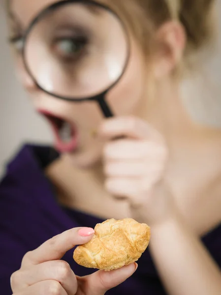 Wanita memegang kaca pembesar menyelidiki roti — Stok Foto
