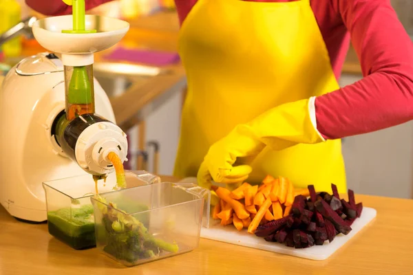 Göra grönsaker juice i juicepress maskin — Stockfoto