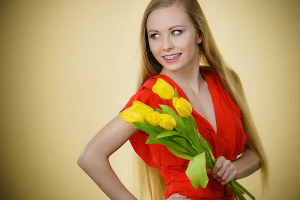 Pretty woman s bandou žluté tulipány — Stock fotografie