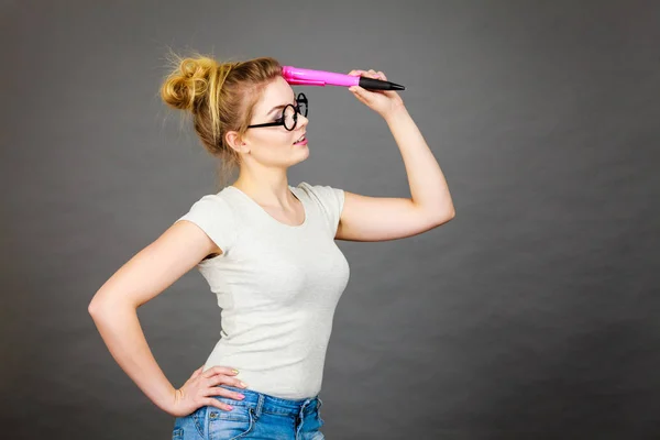 Mujer sosteniendo un gran lápiz de gran tamaño pensando en algo —  Fotos de Stock