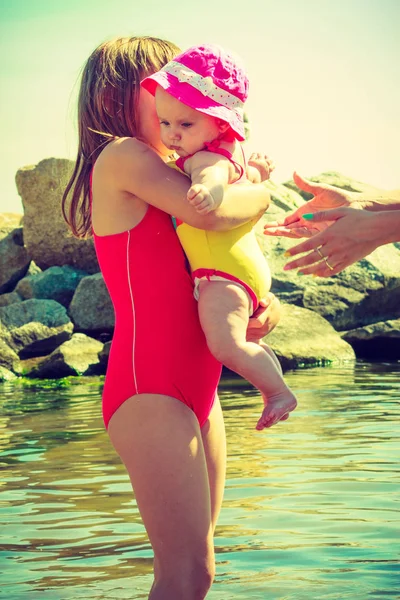Mujer abrazando bebé en el agua — Foto de Stock