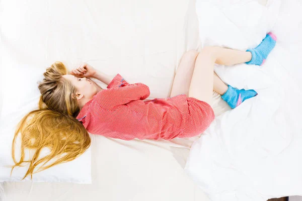 Jovem deitada na cama usando pijama — Fotografia de Stock