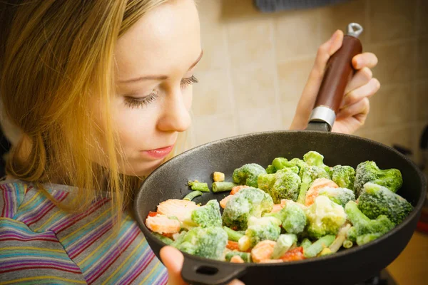Žena vaření míchejte smažit Zmrazená zelenina na pánvi — Stock fotografie