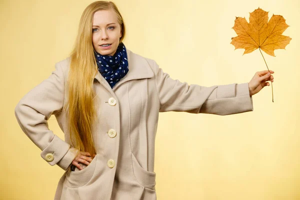 Kobieta trzyma pomarańczowy liść jesieni — Zdjęcie stockowe
