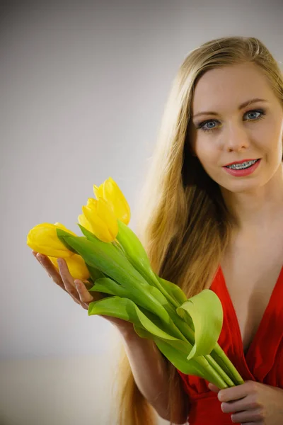 Pretty woman with yellow tulips bunch — Stock Photo, Image