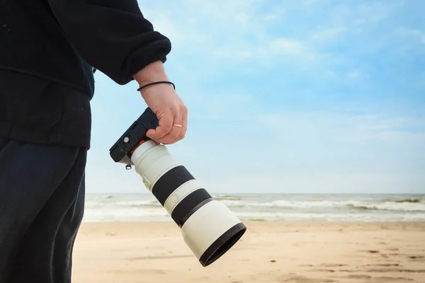 Uomo a piedi sulla spiaggia con macchina fotografica — Foto Stock