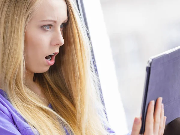 Schockiertes Mädchen schaut auf Tablet zu — Stockfoto