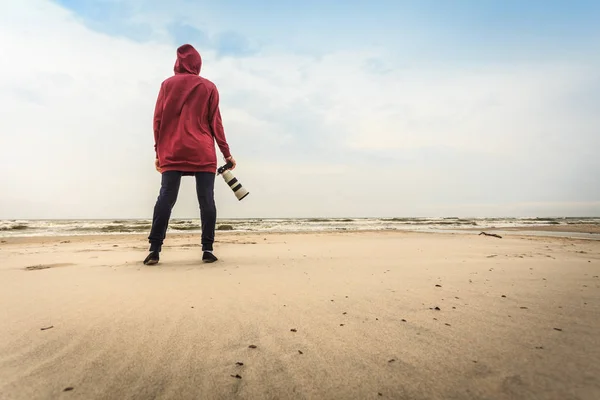 Kobieta spacerująca po plaży z kamerą — Zdjęcie stockowe