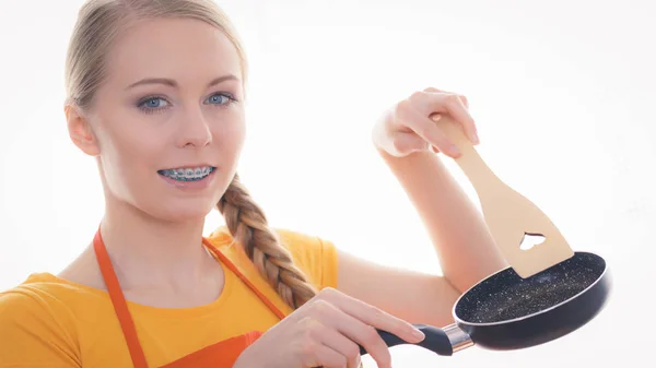 Woman holding cooking pan and spatula — Stock Photo, Image