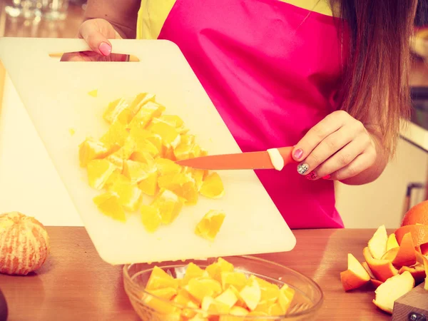 Mujer ama de casa en cocina corte de frutas naranja — Foto de Stock