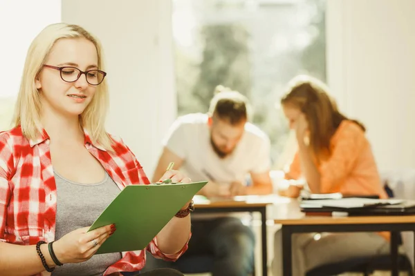 Studentka před její kamarádi v učebně — Stock fotografie