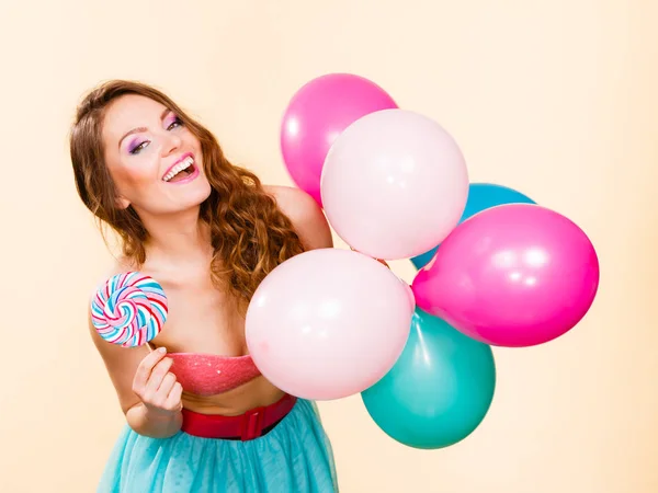 Woman holds lollipop candy and balloons — Stock Photo, Image