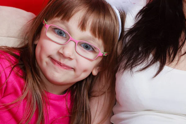 Kleines Mädchen in Brille sitzt auf Sofa — Stockfoto