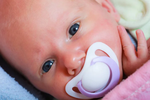 Pasgeboren baby liggend in bed met dummy — Stockfoto