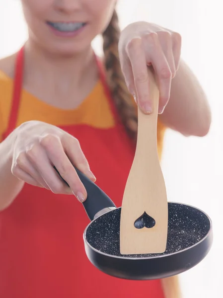 Woman hand holding cooking pan and spatula — Stock Photo, Image