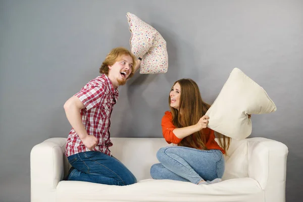 Мужчина и женщина дерутся подушками — стоковое фото