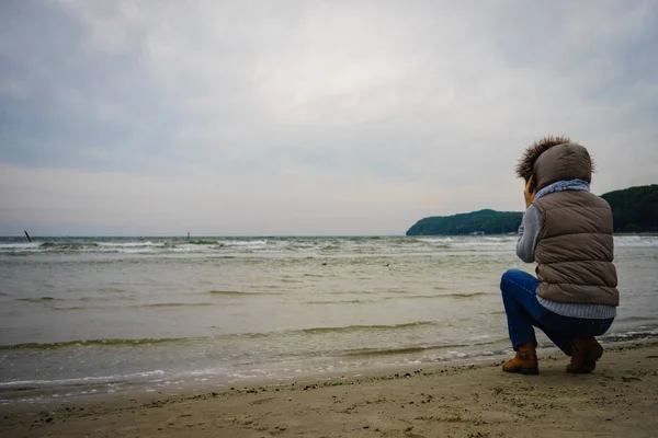 Frau spaziert am Strand, herbstlicher kalter Tag — Stockfoto