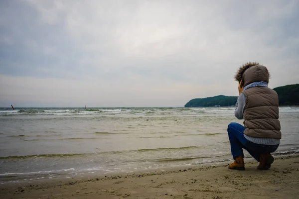 在海滩漫步的妇女, 秋天冷的天 — 图库照片