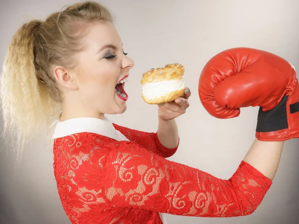 Woman fighting off bad food, boxing cream puff cake — Stock Photo, Image