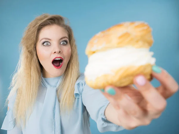 Funny woman holds cream puff cake — Stock Photo, Image