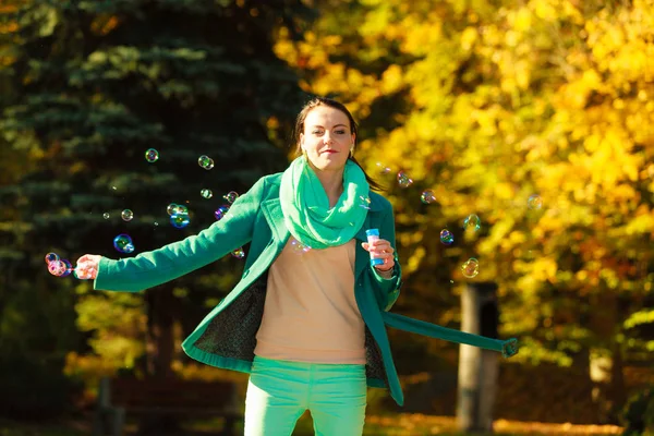 Женщина, гуляющая в парке, делает мыльный пузырь — стоковое фото