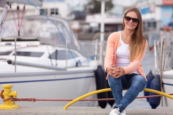 Attractive girl sitting on pier. — Stock Photo, Image