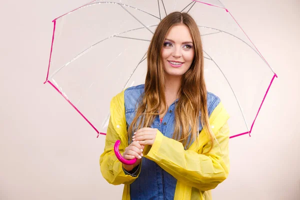 Женщина в водонепроницаемом пальто под зонтиком — стоковое фото