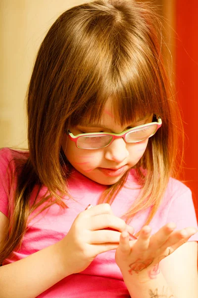 Pequena menina criança desenho em seu braço — Fotografia de Stock