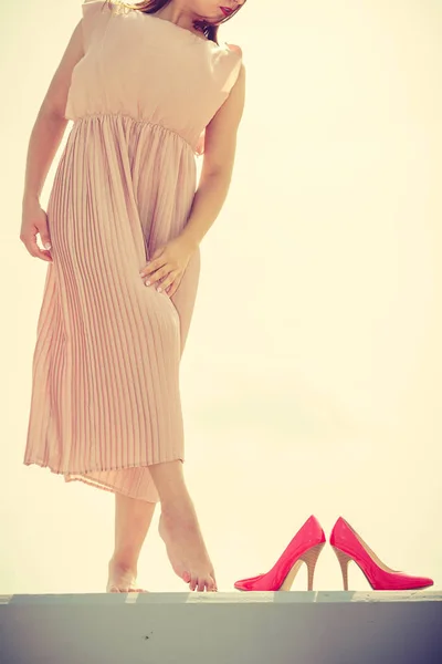 Kobieta nosi długie, jasne różowa sukienka na molo — Zdjęcie stockowe