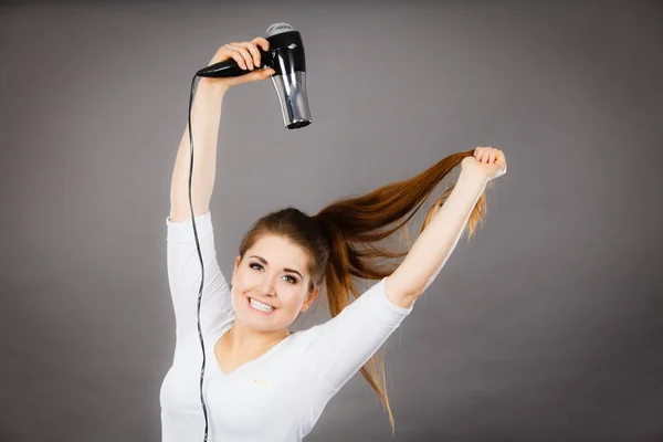 Frau trocknet ihr Haar mit Haartrockner — Stockfoto