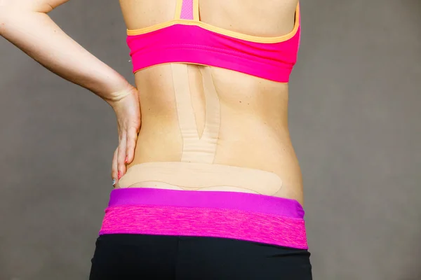 Kobieta z medycznych kinesio taping na plecach — Zdjęcie stockowe