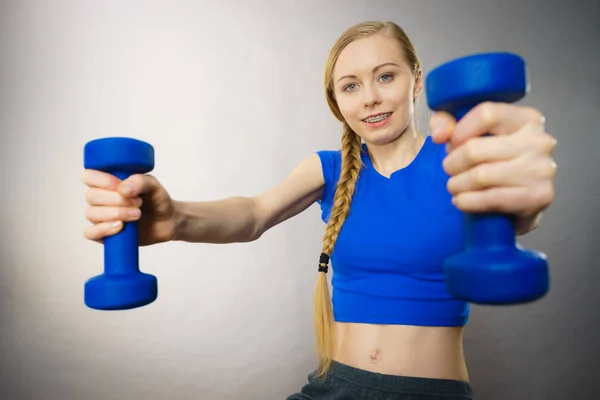 Teenage woman working out at home with dumbbell — Stock Photo, Image