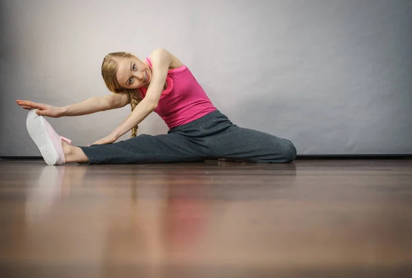 Vrouw in sportkleding benen rekken — Stockfoto