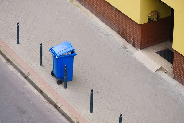 Lata de lixo azul no pavimento de rua — Fotografia de Stock