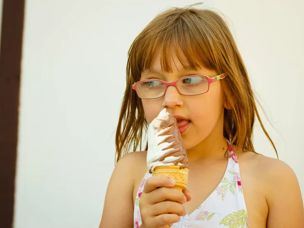 幼児女の子で眼鏡をかけて食べるアイスクリーム — ストック写真