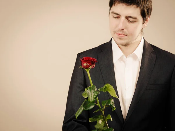 Eleganter junger Mann mit roter Rose. — Stockfoto