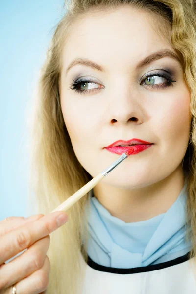 Het aanbrengen van lippenstift op modellippen — Stockfoto