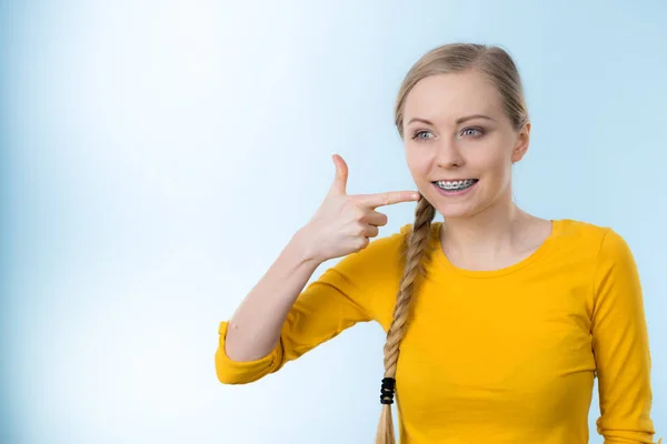 Mujer mostrando sus dientes con aparatos ortopédicos — Foto de Stock