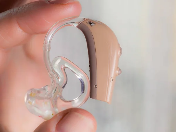 Senior person holding hearing aid closeup — Stock Photo, Image