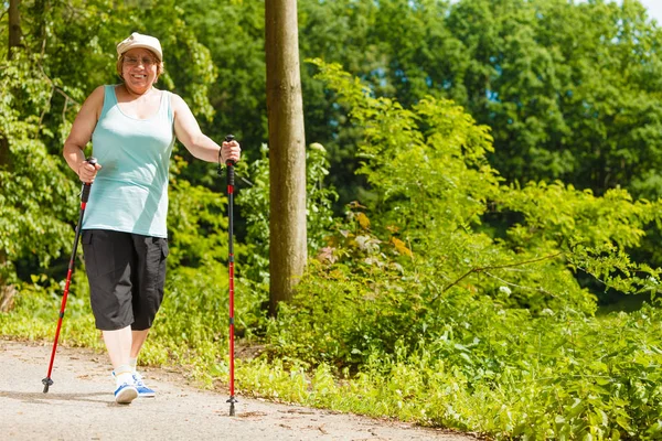 Mujer mayor practicando nordic walking en el parque —  Fotos de Stock