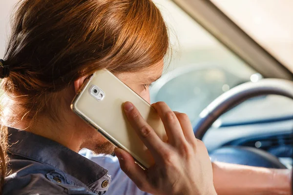 Мужчина разговаривает по телефону во время вождения автомобиля . — стоковое фото