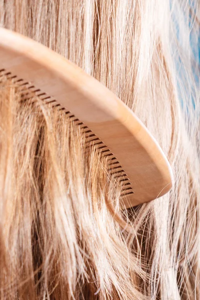 Прямые каштановые волосы с деревянным гребнем крупным планом — стоковое фото