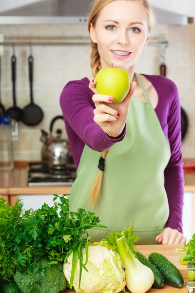 Femme jeune femme au foyer dans la cuisine avec des pommes — Photo