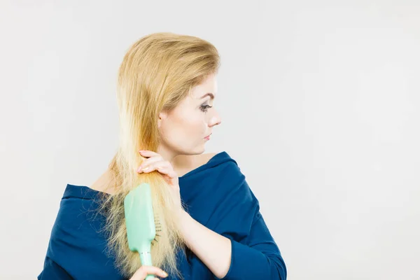 Женщина расчесывает длинные волосы щеткой — стоковое фото