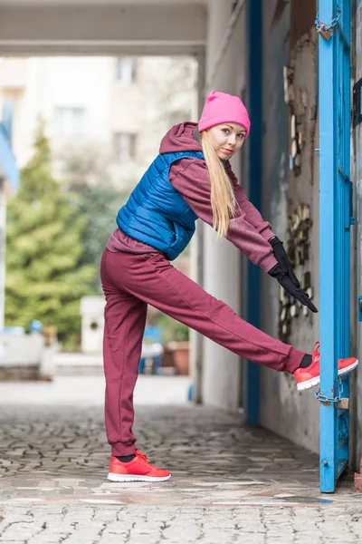 Ragazza sportiva che si estende all'aperto sulla strada della città . — Foto Stock