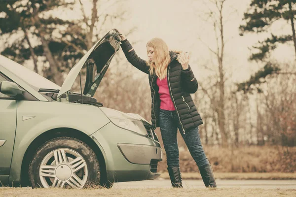 Mulher loira e quebrado carro na estrada — Fotografia de Stock